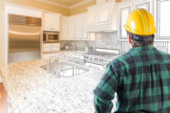 contractor with hardhat looking at kitchen drawing